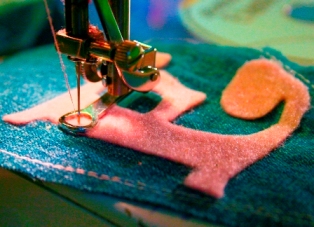 Author's photograph of appliqueing her denim bunting